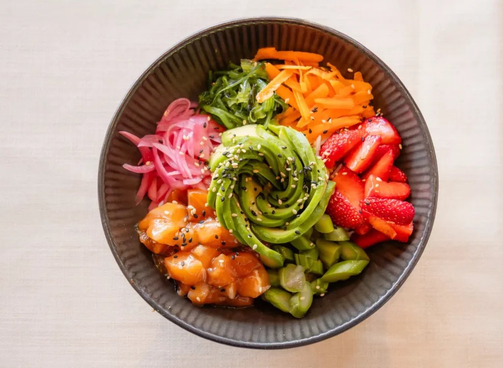 Bowl colorido con salmón, verduras frescas y arroz en el restaurante Ca Na Marcè, Puerto de Alcudia, Mallorca.
