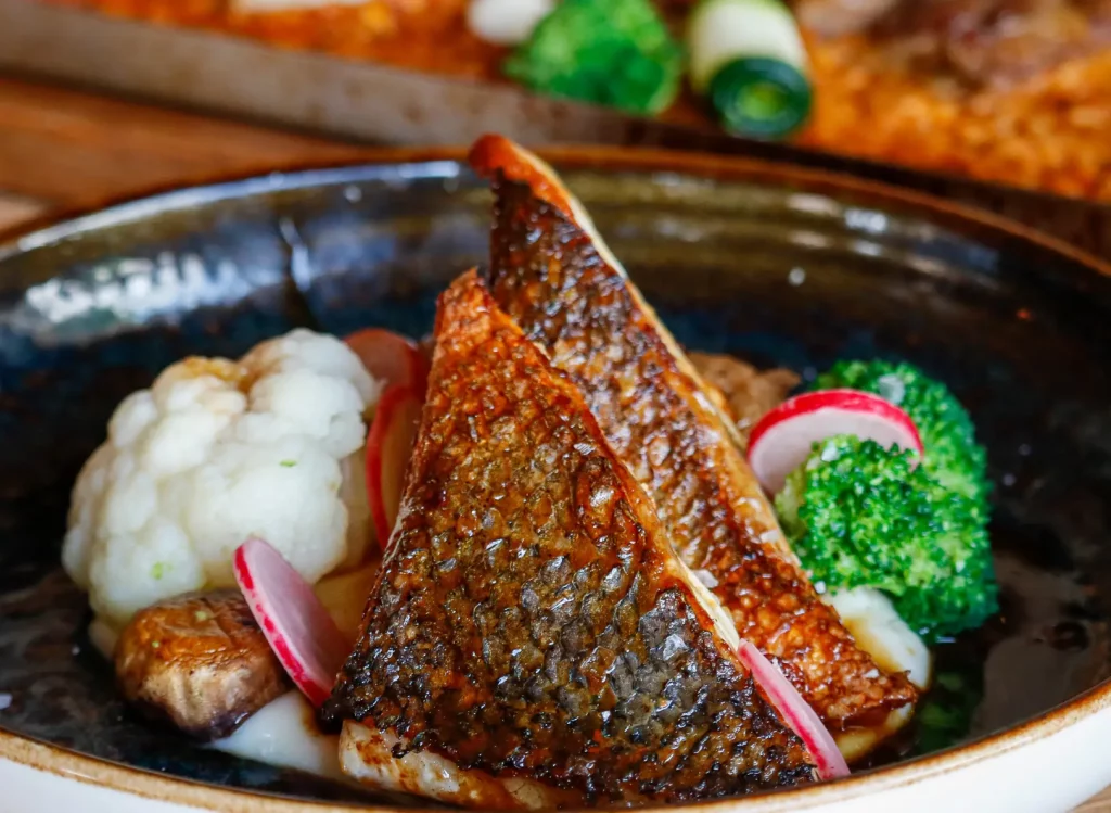 Plato de pescado con guarnición en el restaurante Ca Na Marcè, Puerto de Alcudia, Mallorca